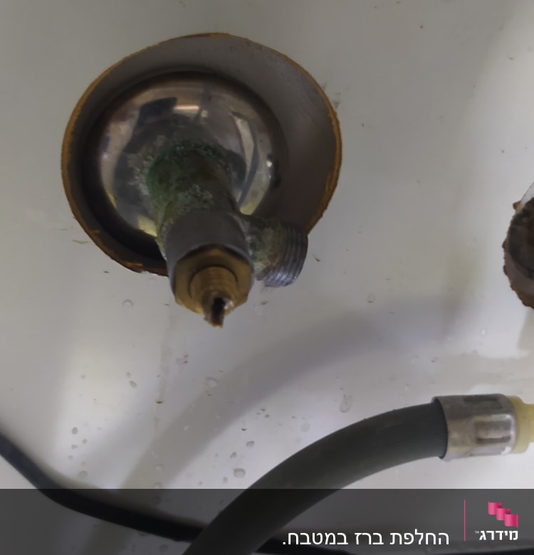 ברז מתכת חלוד עם צינור מחובר